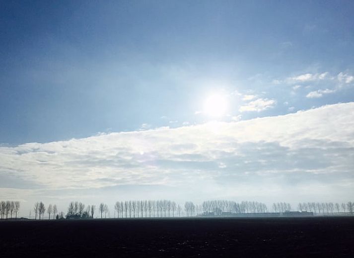 Stilvoller Innenraum des Ferienhauses in Schoondijke, Zeeuws-Vlaanderen, mit grossen Fenstern und einer gemuetlichen Sitzecke.
