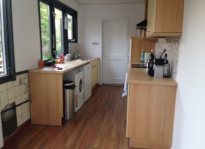 Gezellige woonkamer in vakantiehuis Landstraat, Aardenburg, Zeeland met uitzicht op tuin en terras.