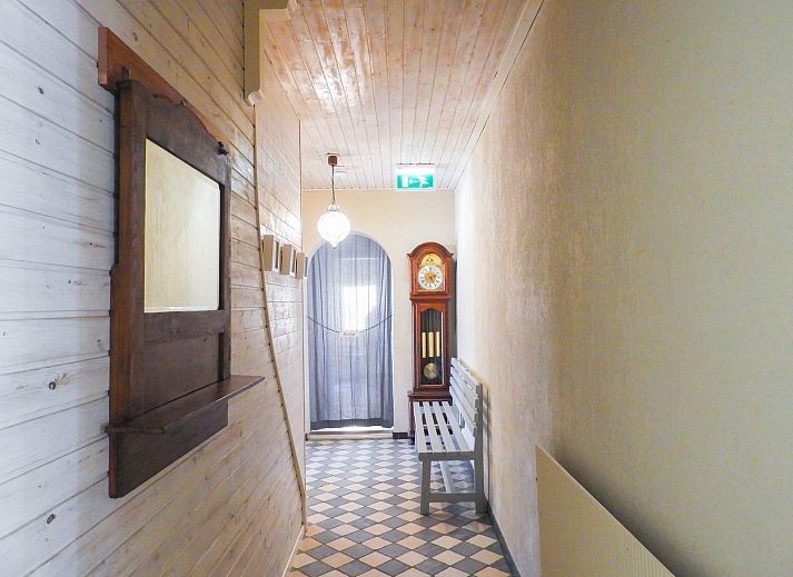 VZ039 Groepsaccommodatie Sluis, achtertuin met zonnige veranda en groene bomen.