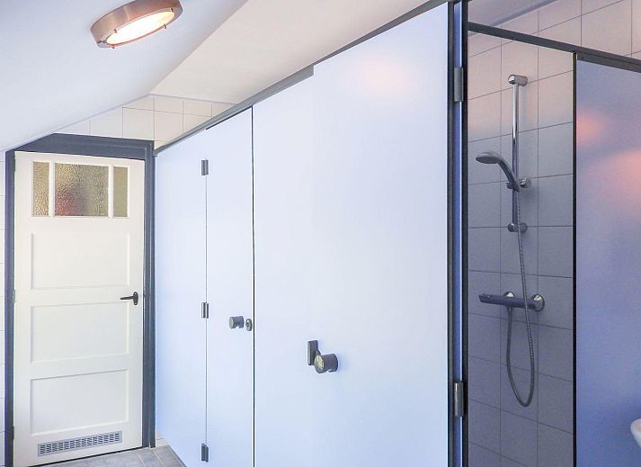 VZ039 Groepsaccommodatie Sluis, achtertuin met zonnige veranda en groene bomen.