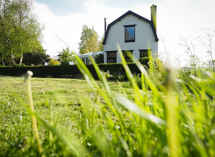 Vakantiehuis in Sluis biedt een rustieke ervaring in Zeeuws-Vlaanderen, Zeeland, omgeven door groene natuur en een zonnig terras.