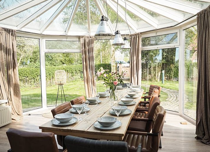 Vakantiehuis in Sluis biedt een rustieke ervaring in Zeeuws-Vlaanderen, Zeeland, omgeven door groene natuur en een zonnig terras.