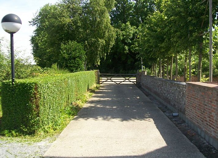 Vakantiehuis in Sluis, Zeeuws-Vlaanderen, omgeven door groene natuur en een uitgestrekt gazon, ideaal voor een ontspannen verblijf.