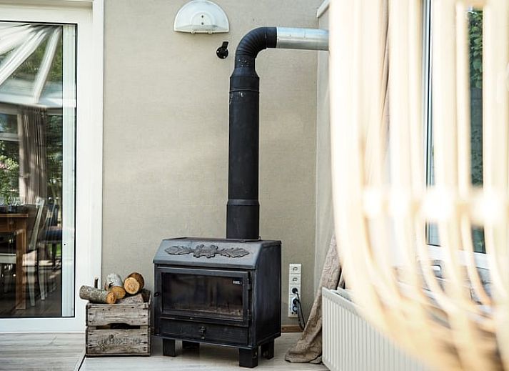 Lichte eetkamer in Vakantiehuis in Sluis, Zeeuws-Vlaanderen, met uitzicht op groene tuin. Perfect voor een ontspannen verblijf in Zeeland.