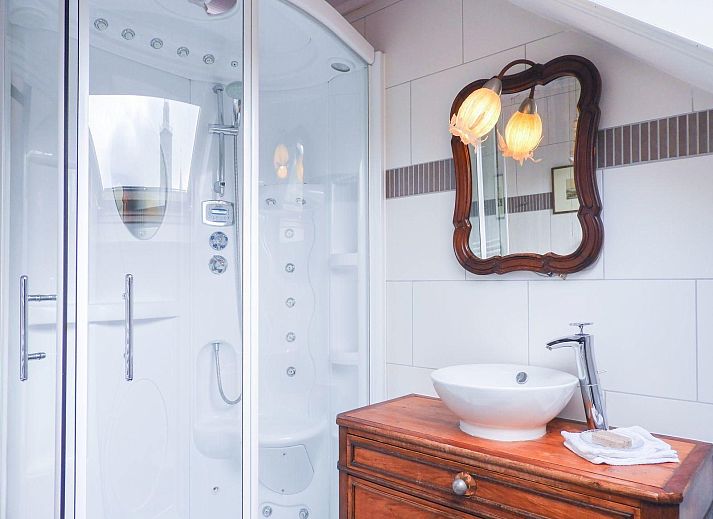 Cozy garden at VZ052 Apartment Sluis in Sluis, Zeeuws-Vlaanderen with parasol and seating area.