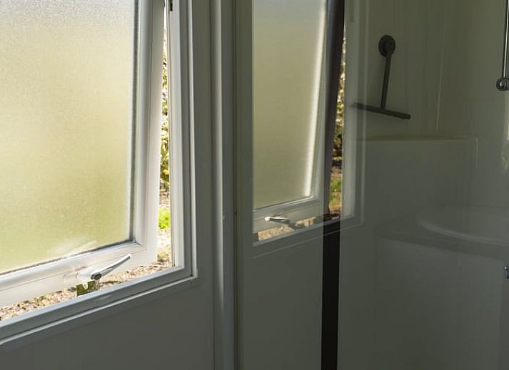 Vakantiehuisje in Hengstdijk, Zeeuws-Vlaanderen met zonnige veranda en groene omgeving, ideaal voor ontspannen verblijf in Zeeland.