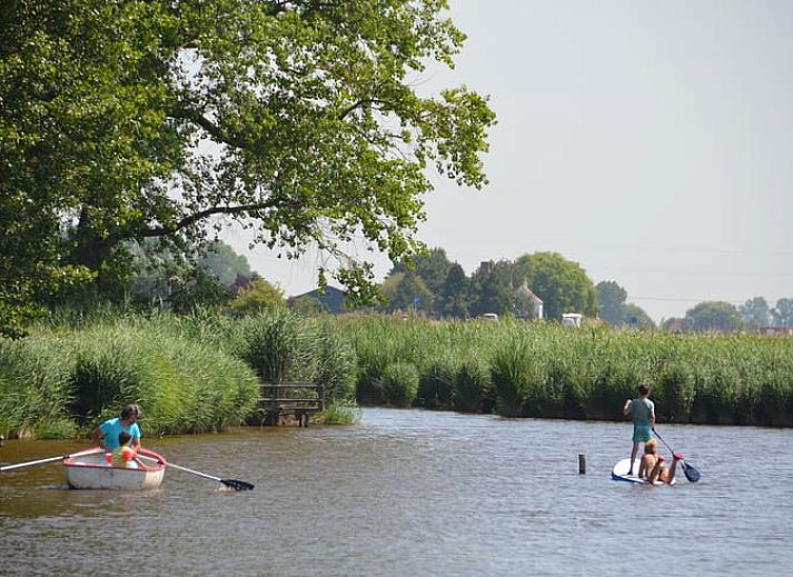 Blick auf die gruene Umgebung und den Fluss im Ferienhaus in Oostburg, ideal fuer Naturliebhaber in Zeeland.