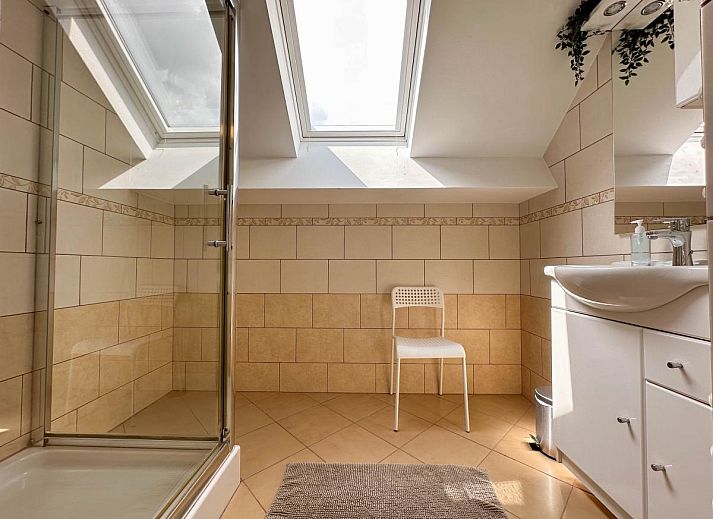 Gezellige veranda bij Bronzigt vakantiehuis in Terneuzen, met uitzicht op de tuin.