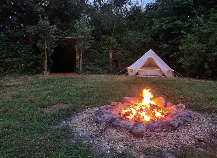 Groen veld met tent bij Huisje in Terneuzen, een serene vakantieaccommodatie in Zeeland.