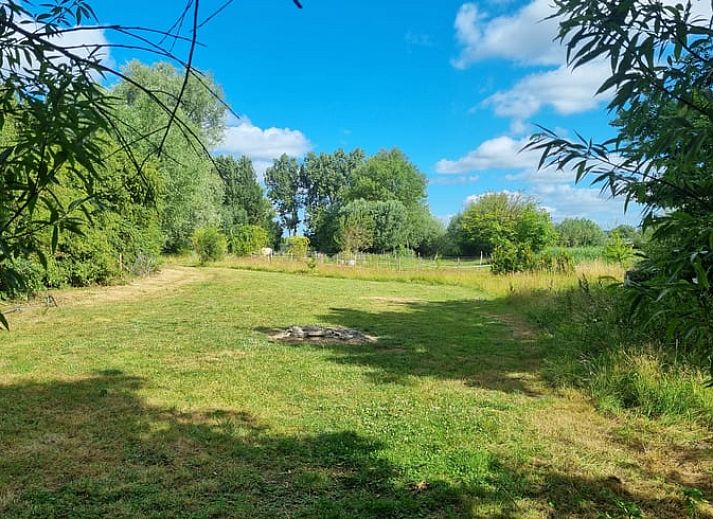 Groen veld met tent bij Huisje in Terneuzen, een serene vakantieaccommodatie in Zeeland.