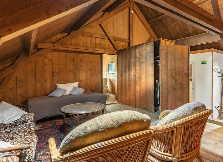 Gezellige woonkamer met kroonluchter in Vakantiehuis Groepswoning De Appelgaard, Zaamslag, perfect voor ontspanning.