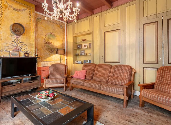 Gezellige woonkamer met kroonluchter in Vakantiehuis Groepswoning De Appelgaard, Zaamslag, perfect voor ontspanning.