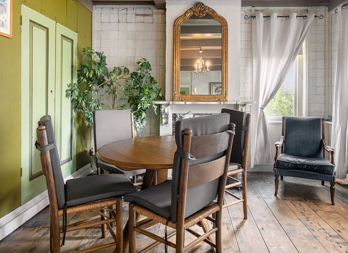 Gezellige woonkamer met kroonluchter in Vakantiehuis Groepswoning De Appelgaard, Zaamslag, perfect voor ontspanning.