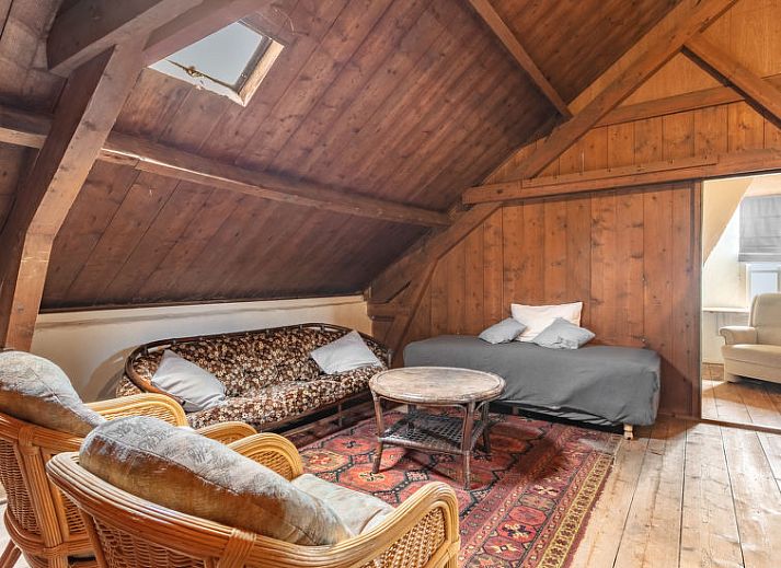 Gezellige woonkamer met kroonluchter in Vakantiehuis Groepswoning De Appelgaard, Zaamslag, perfect voor ontspanning.