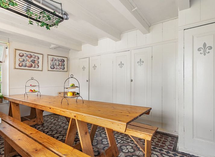 Buitenruimte met picknicktafel bij Vakantiehuis Groepswoning De Appelgaard, Zaamslag, omgeven door groene natuur.