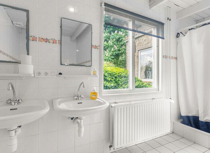 Buitenruimte met picknicktafel bij Vakantiehuis Groepswoning De Appelgaard, Zaamslag, omgeven door groene natuur.