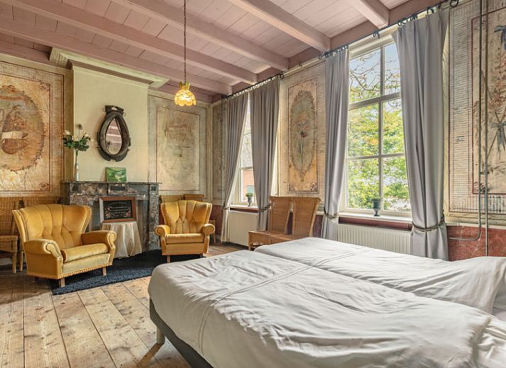 Buitenruimte met picknicktafel bij Vakantiehuis Groepswoning De Appelgaard, Zaamslag, omgeven door groene natuur.