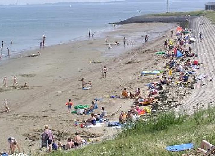 Spacious terrace at Vermare in Wemeldinge, South Beveland, with comfortable garden chairs and parasol.