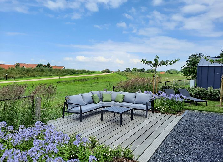 Dining room in Holiday home Ruisweg 83, Wemeldinge, with wooden table and view of outside.