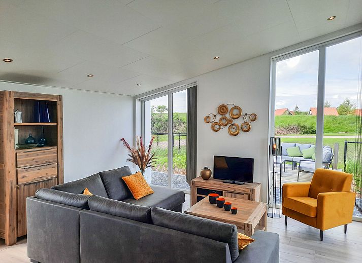 Dining room in Holiday home Ruisweg 83, Wemeldinge, with wooden table and view of outside.