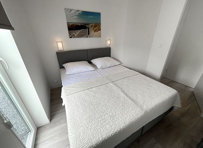 Dining room in Holiday home Ruisweg 83, Wemeldinge, with wooden table and view of outside.