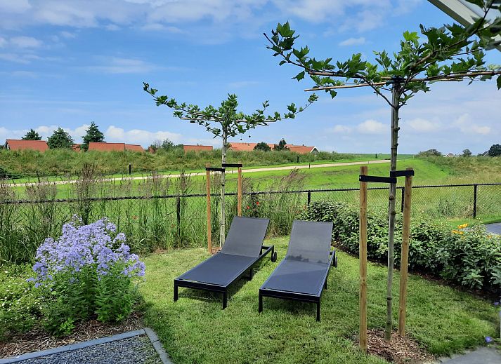 Dining room in Holiday home Ruisweg 83, Wemeldinge, with wooden table and view of outside.