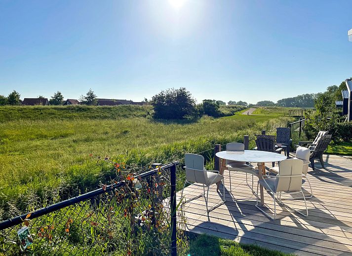 Exterieur van Vakantiehuis Ruisweg 73 in Wemeldinge, Zeeland, met ruim terras en prachtig uitzicht op de groene omgeving.