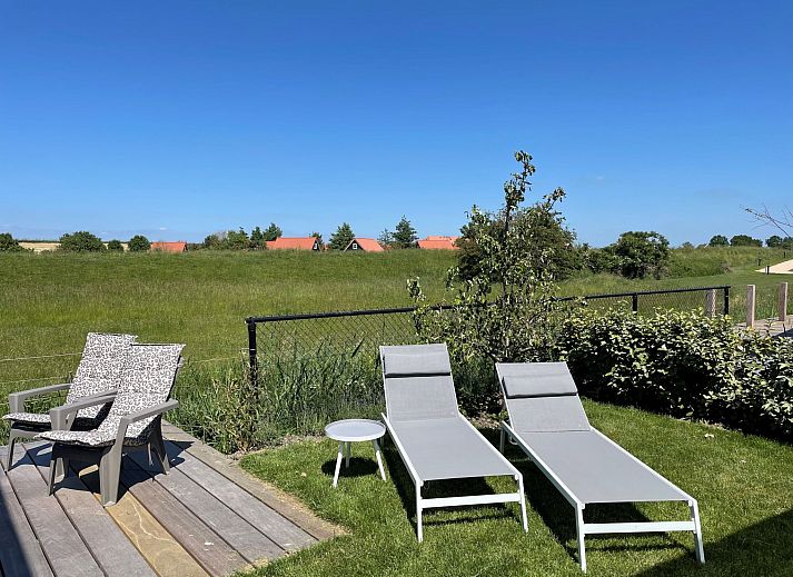 Gezellige binnenruimte van Vakantiehuis Ruisweg 73, Wemeldinge, met comfortabele meubels en grote ramen voor veel lichtinval.