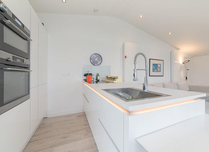 Voorzijde van Vakantiehuis Waterresort Oosterschelde, huisnr. 46 in Wemeldinge, omgeven door groen in Zuid-Beveland, Zeeland.