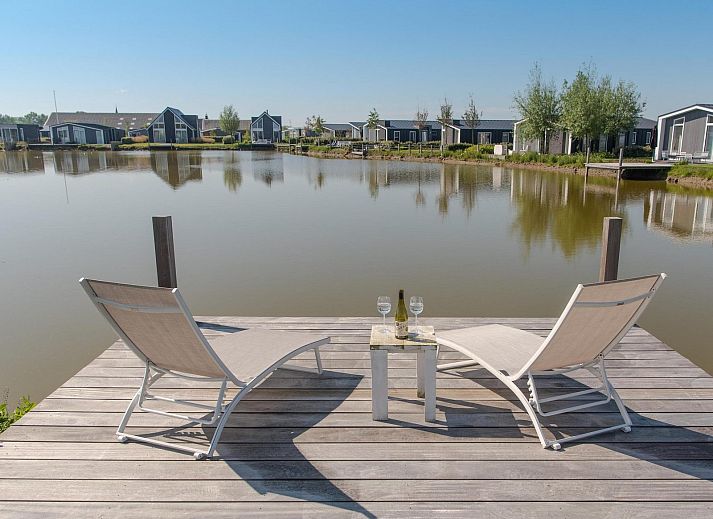 Voorzijde van Vakantiehuis Waterresort Oosterschelde, huisnr. 46 in Wemeldinge, omgeven door groen in Zuid-Beveland, Zeeland.