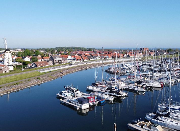 Lichte woonkamer in Vakantiehuis Waterresort Oosterschelde, huisnr. 46 in Wemeldinge, met uitzicht op de tuin in Zeeland.