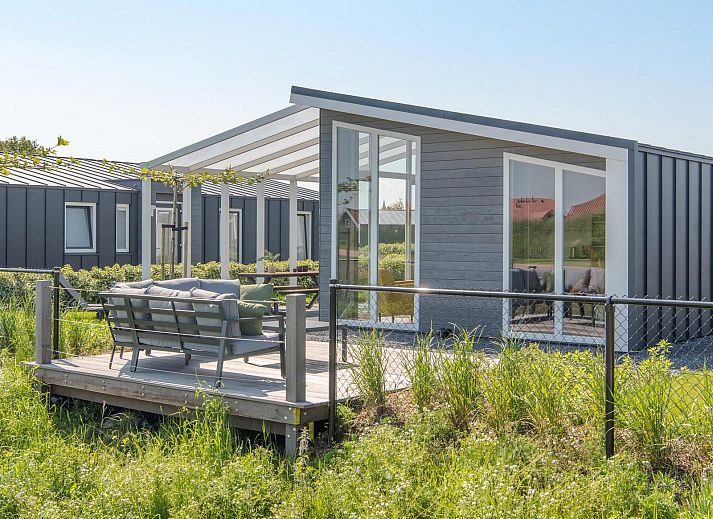 Gemuetliches Wohnzimmer im Ferienhaus Waterresort Oosterschelde Haus Nr. 83 in Wemeldinge, Zuid-Beveland, mit Blick auf den Garten.