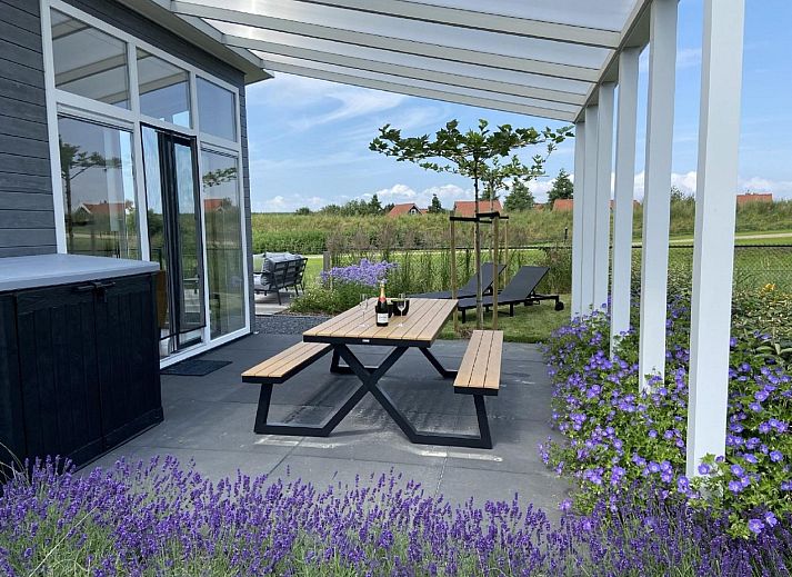 Gemuetliches Wohnzimmer im Ferienhaus Waterresort Oosterschelde Haus Nr. 83 in Wemeldinge, Zuid-Beveland, mit Blick auf den Garten.