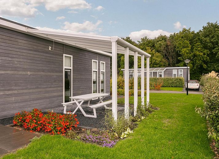 Achtertuin van Vakantiehuis Waterresort Oosterschelde - huisnr. 70 in Zuid-Beveland, met grasveld en terras.