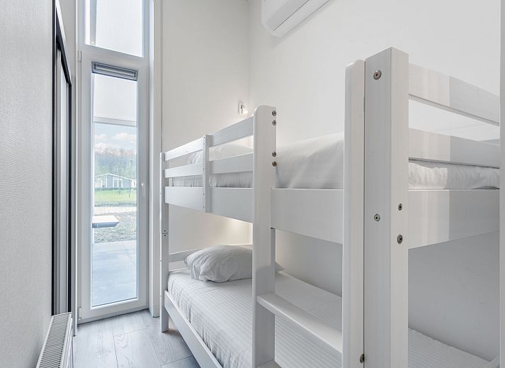 Eetkamer van Vakantiehuis Ruisweg 12, Wemeldinge, Zeeland, met stijlvolle eettafel en hanglampen, ideaal voor familiediners.