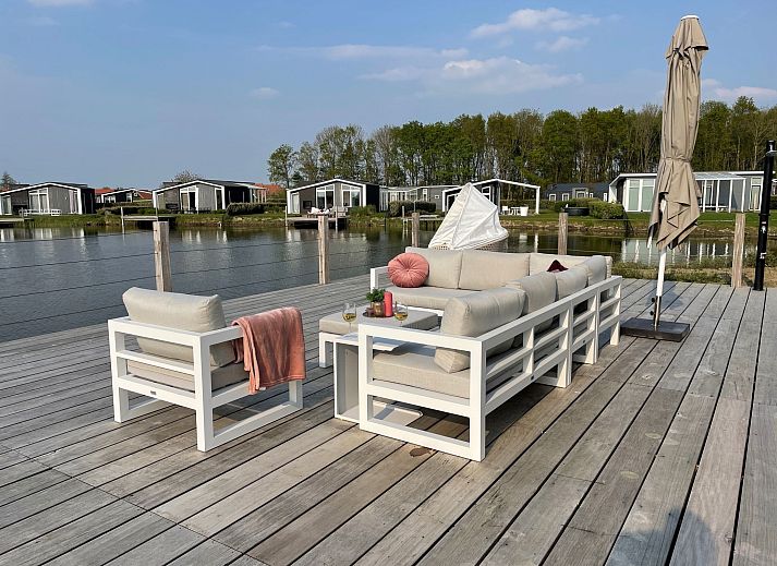 Eetkamer van Vakantiehuis Ruisweg 12, Wemeldinge, Zeeland, met stijlvolle eettafel en hanglampen, ideaal voor familiediners.