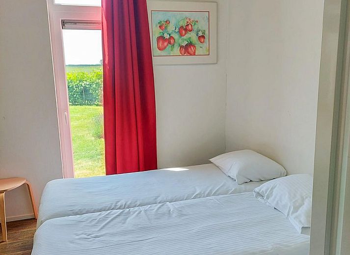 Innenansicht des Ferienhauses Waterresort Oosterschelde Haus Nr. 51, helles Esszimmer mit Blick auf den Garten in Wemeldinge, Zeeland.