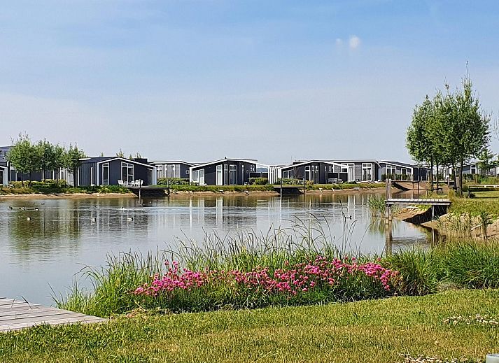 Bequemer Sessel im Wohnzimmer des Ferienhauses Waterresort Oosterschelde Haus Nr. 51 in Wemeldinge, mit Blick auf den Garten.