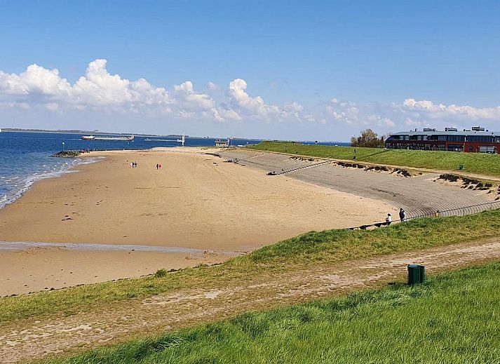 Stilvolles Wohnzimmer im Ferienhaus Waterresort Oosterschelde Haus Nr. 55, Wemeldinge, Zuid-Beveland, mit offener Kueche und grossen Fenstern.