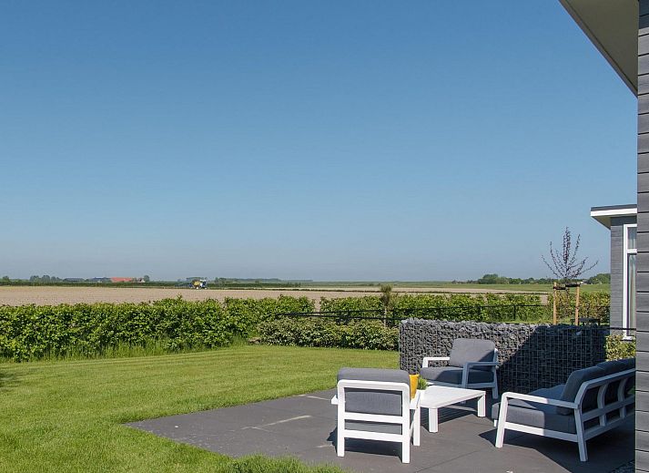 Zijaanzicht van Vakantiehuis Waterresort Oosterschelde huisnr. 39 in Wemeldinge, omgeven door weelderige tuin.