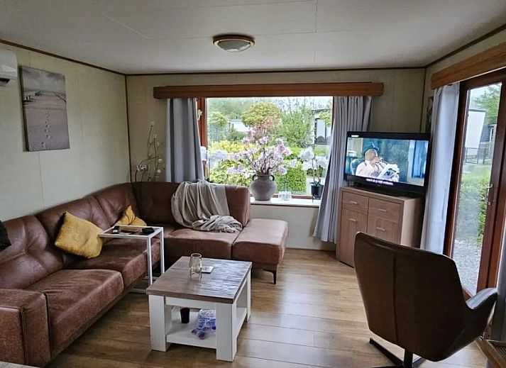 Aussenbereich des Ferienhauses mit 4 Staemmen auf dem Campingplatz Ardoer in Zuid-Beveland, mit Terrasse und Garten