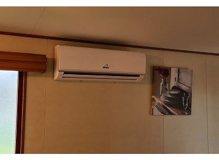 Aussenbereich des Ferienhauses mit 4 Staemmen auf dem Campingplatz Ardoer in Zuid-Beveland, mit Terrasse und Garten