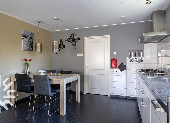 Gemuetlicher Garten des Ferienhauses ZE207 in Oud Sabbinge, mit Sitzgelegenheiten und bunten Blumen.