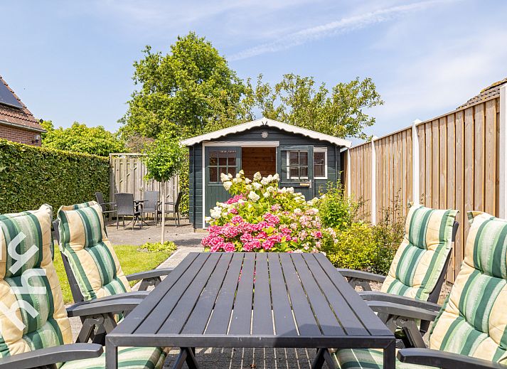 Gemuetlicher Garten des Ferienhauses ZE207 in Oud Sabbinge, mit Sitzgelegenheiten und bunten Blumen.