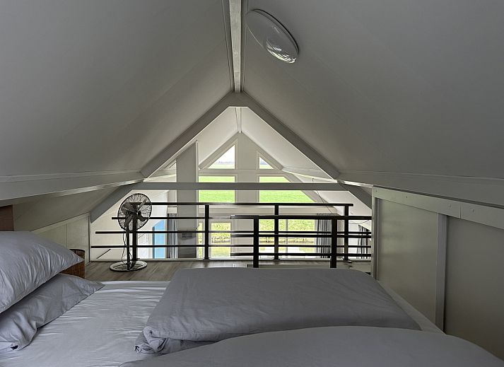 Rustige omgeving van vakantiehuis ZE1365 in Kattendijke, met uitzicht op een groene weide en kerktoren.