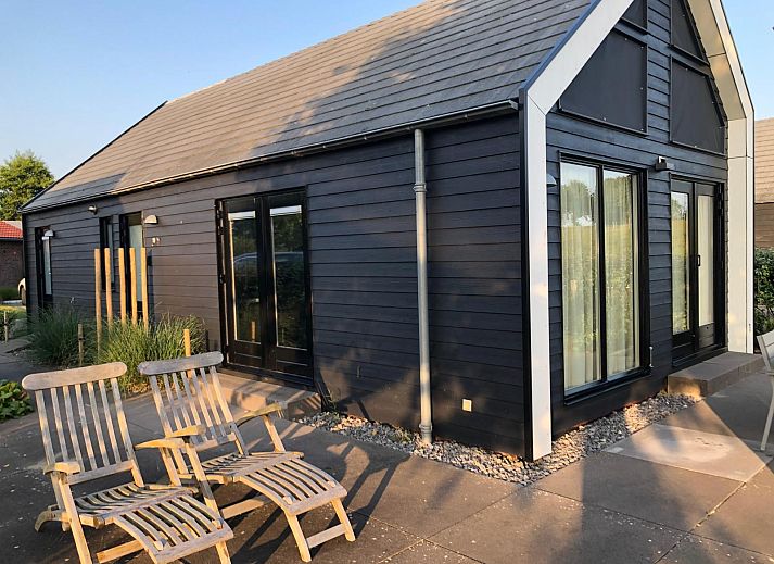 Rustige omgeving van vakantiehuis ZE1365 in Kattendijke, met uitzicht op een groene weide en kerktoren.