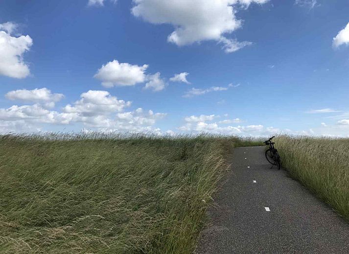 Rustige omgeving van vakantiehuis ZE1365 in Kattendijke, met uitzicht op een groene weide en kerktoren.