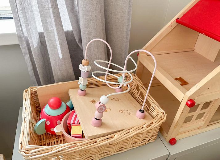 Gezellige binnenruimte van vakantiehuis Timmerman in Heinkenszand, Zuid-Beveland, met comfortabele kussens en speelhoek voor kinderen.