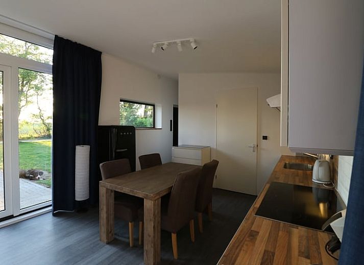 Buitenruimte met houten tafel bij Vakantiehuisje in Wolphaartsdijk, Zuid-Beveland voor ontspannen momenten.