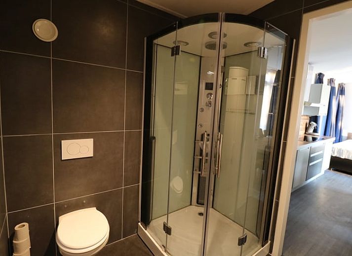 Buitenruimte met houten tafel bij Vakantiehuisje in Wolphaartsdijk, Zuid-Beveland voor ontspannen momenten.